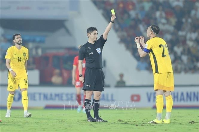 Trọng tài rút thẻ vàng cảnh cáo cầu thủ Dion Cools của Malaysia. Ảnh: Minh Quyết - TTXVN