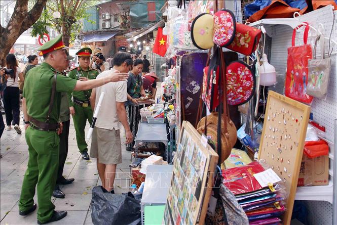 Tổ công tác của Công an phường Hoàn Kiếm xử lý vi phạm về trật tự đô thị tại phố Trần Phú. Ảnh: Phạm Kiên - TTXVN