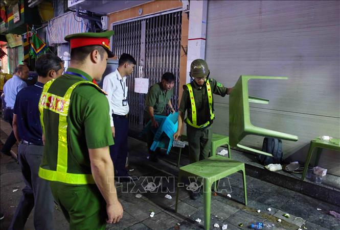Tổ công tác Công an phường Hoàn Kiếm phát hiện và thu giữ tang vật của một cơ sở kinh doanh dịch vụ ăn uống lấn chiếm vỉa hè trên phố Nguyễn Siêu. Ảnh: Phạm Kiên - TTXVN