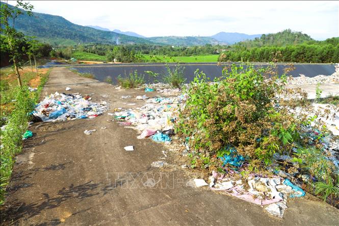 Khu vực bờ bao, ven đường nội bộ các hộ chôn lấp ngổn ngang những đống rác, cây dại mọc. Ảnh: Xuân Tiến - TTXVN 
