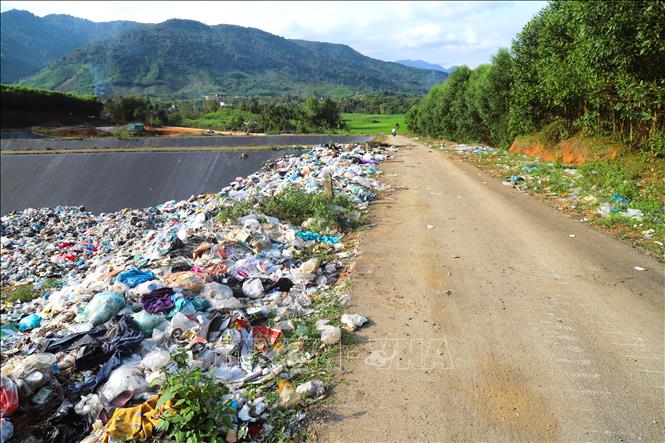 Rác thải đổ tràn lên cả khu vực bờ bao, ven đường nội bộ tại bãi xử lý rác thải Quế Phong. Ảnh: Xuân Tiến - TTXVN 