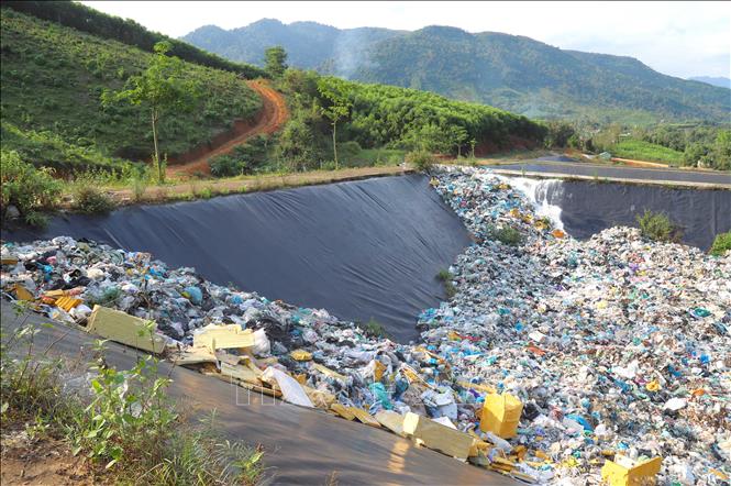 Mặc dù hố chôn lấp có đường dẫn phục vụ xe chở rác xuống lòng hố nhưng rác thải vẫn được đổ trực tiếp từ trên đường nội bộ xuống các góc của hố chôn lấp rác. Ảnh: Xuân Tiến - TTXVN 