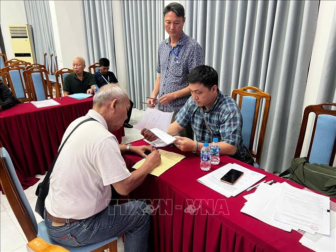 UBND phường hỗ trợ hoàn thiện hồ sơ bàn giao đất cho người dân. Ảnh: Kim Anh - TTXVN 