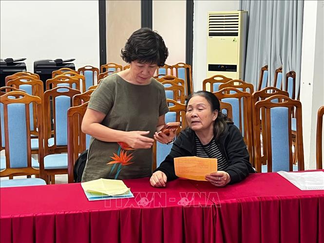 Người dân hoàn thiện hồ sơ bàn giao đất. Ảnh: Hải Yến - TTXVN phát