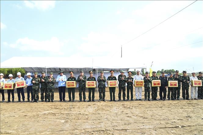Thượng tướng Nguyễn Quang Ngọc, Thứ trưởng Bộ Quốc phòng cùng lãnh đạo UBND tỉnh Cà Mau tặng quà và động viên kỹ sư và công nhân tại công trình. Ảnh: Văn Đông / TTXVN phát.