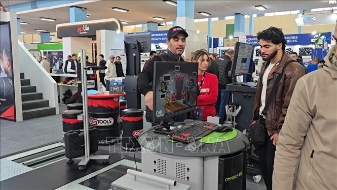 Khách tham quan hệ thống chẩn đoán tự động xe hơi của một doanh nghiệp nước ngoài tại Triển lãm. Ảnh: Nguyễn An - PV TTXVN tại Algeria