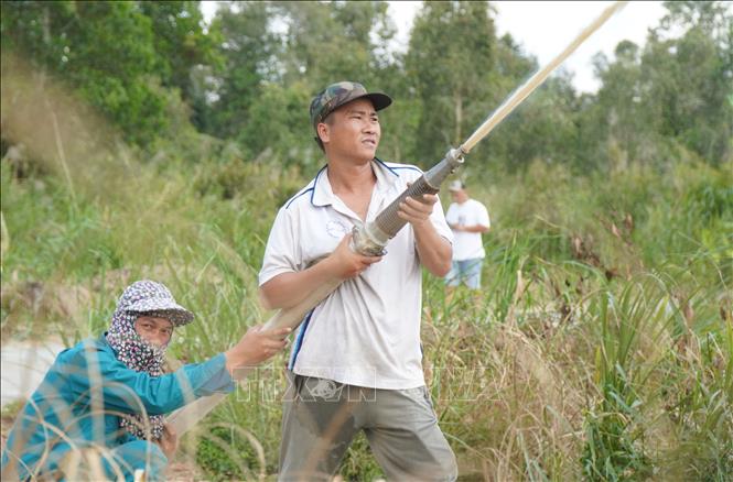 Lực lượng phòng cháy Vườn Quốc gia U Minh Hạ phối hợp người dân ven rừng phòng cháy. Ảnh: Tuấn Phi – TTXVN 