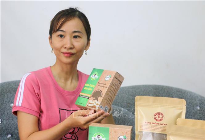 Chị Nguyễn Hoàng Ngọc Yến (xã Bình Hòa, An Giang) giới thiệu về sản phầm bánh phồng nấm rơm và các sản phẩm chế biến sâu từ nấm rơm. Ảnh: Công Mạo-TTXVN