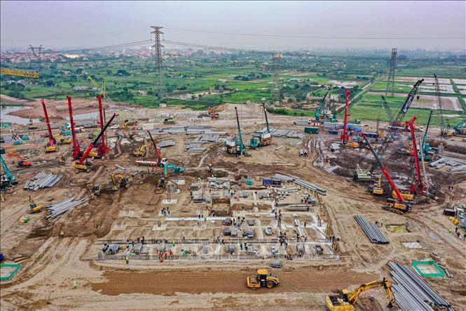 Phương tiện máy móc và thiết bị chuyên dụng hoạt động không ngừng, đào đất, hạ cốt nền và san phẳng mặt bằng, giúp xử lý nhanh khối lượng đất lớn và đẩy nhanh tiến độ san nền cũng như thi công móng. Ảnh: Trung Nguyên - TTXVN