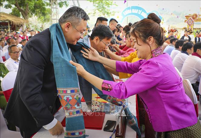 Những thiếu nữ dân tộc Lào ở Núa Ngam tặng khăn thổ cẩm cho đại biểu. Ảnh: Xuân Tư - TTXVN