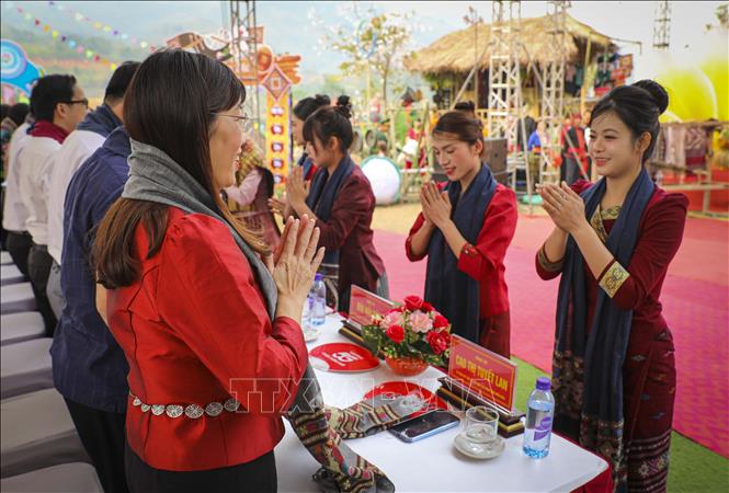 Nghi thức chắp tay chào theo phong tục truyền thống của người Lào, thể hiện sự tôn trọng và lời chúc tốt lành trong ngày hội. Ảnh: Xuân Tư - TTXVN