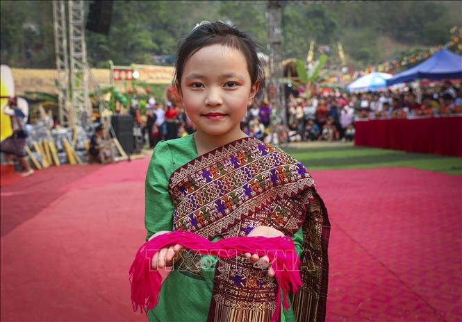 Em bé dân tộc Lào cầm trên tay những sợi chỉ để thực hiện nghi thức buộc chỉ cổ tay, cầu may trong Lễ hội Tết Té nước. Ảnh: Xuân Tư - TTXVN
