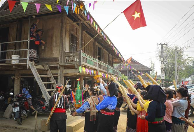 Thầy mô cùng đoàn xin nước đi đến các gia đình thực hiện nghi thức trong ngày hội Tết Té nước. Ảnh: Xuân Tư - TTXVN
