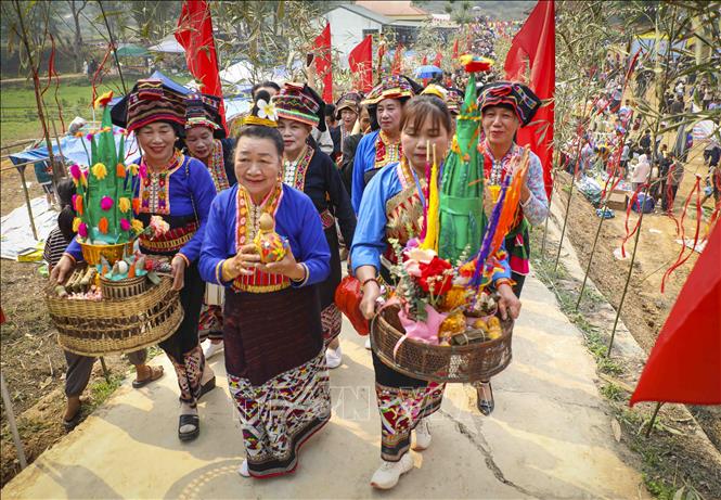 Thầy mô cùng đoàn xin nước đi đến các gia đình thực hiện nghi thức trong ngày hội Tết Té nước. Ảnh: Xuân Tư - TTXVN