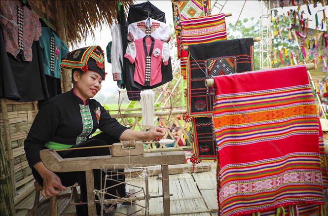 Không gian văn hóa dân tộc Thái với những người phụ nữ đang dệt trang phục dân tộc. Ảnh: Xuân Tư - TTXVN