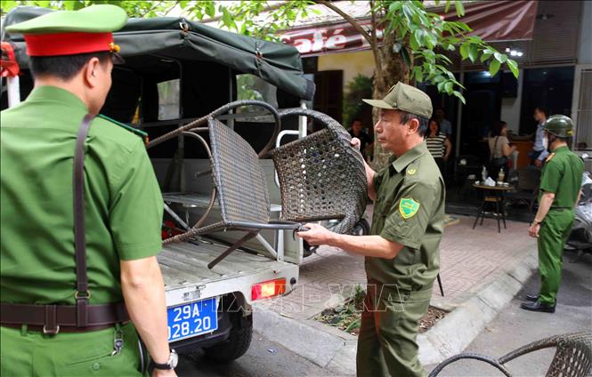 Tổ công tác phường Phương Liệt phát hiện và thu giữ vật dụng của một cơ sở kinh doanh dịch vụ ăn uống lấn chiếm vỉa hè trền phố Nguyễn Ngọc Nại. Ảnh: Phạm Kiên - TTXVN