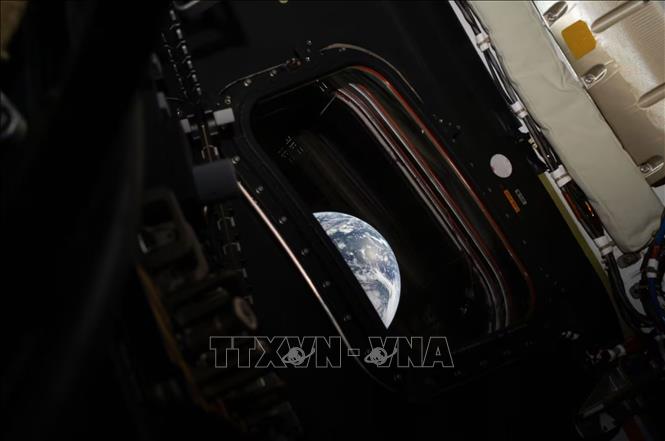 Bức ảnh đầu tiên do chỉ huy đoàn phi hành gia thực hiện sứ mệnh Artemis II Reid Wiseman chụp cho thấy một lát cắt cong của Trái Đất qua cửa sổ khoang tàu, ngày 3/4/2026. Ảnh: CNN/TTXVN 