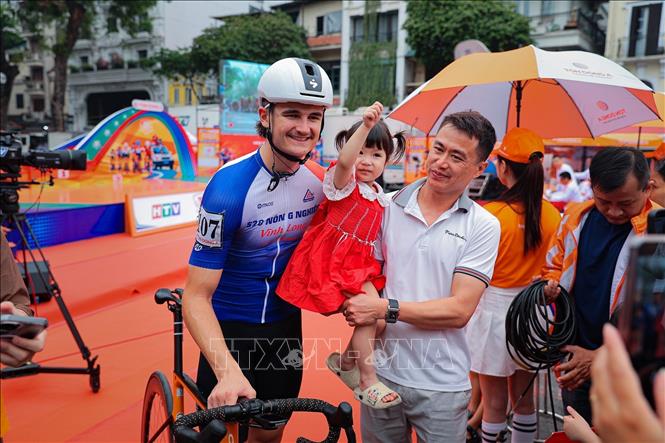 Người hâm mộ chụp ảnh chung với Nick Kergozou De La Boessiere của đội 620 Nông Nghiệp Vĩnh Long người cán đích đầu tiên ở chặng đua vòng quanh Hà Nội dài 42,5km. Ảnh: Phạm Tuấn Anh - TTXVN
