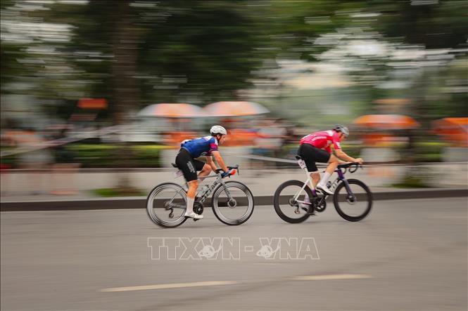 Các tay đua tăng tốc mạnh ở những vòng cuối trước sự cổ vũ của đông đảo người dân hai bên đường. Ảnh: Phạm Tuấn Anh - TTXVN