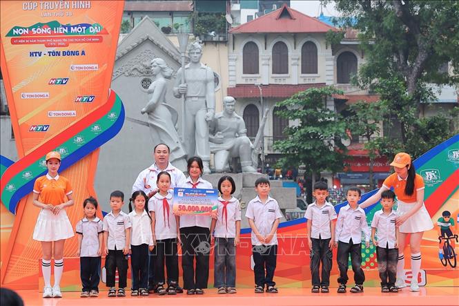 Ông Nguyễn Trịnh Vũ - Giám đốc Cty TNHH MTV Tôn Đông Á Bắc Ninh trao 50 triệu đồng tài trợ học bổng cho các em học sinh có hoàn cảnh khó khăn của Trường Tiểu học Bắc Sơn C, xã Trung Giã, TP Hà Nội. Ảnh: Phạm Tuấn Anh - TTXVN