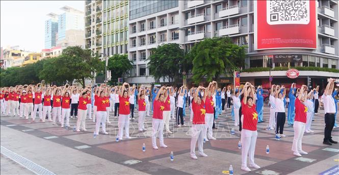 Nhân viên y tế và người dân đồng diễn dưỡng sinh, lan tỏa lối sống khỏe đến cộng đồng. Ảnh: Đinh Hằng - TTXVN