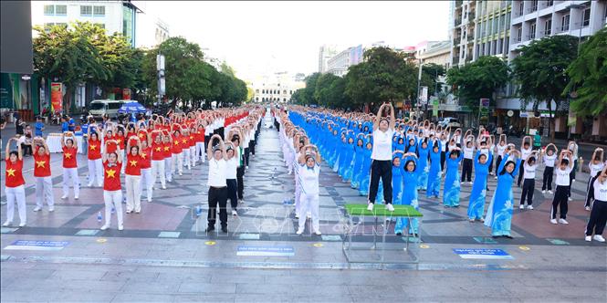 Nhân viên y tế và người dân đồng diễn dưỡng sinh, lan tỏa lối sống khỏe đến cộng đồng. Ảnh: Đinh Hằng - TTXVN