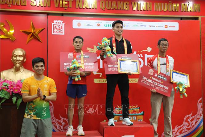 Ban tổ chức trao giải cho các vận động viên đạt thành tích cao ở nội dung cự ly 21km nam. Ảnh: Tạ Toàn – TTXVN