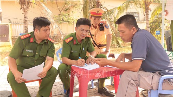 Công an phường Phú Mỹ tiến hành cập nhật thông số các phương tiện vận tải. Ảnh: Huỳnh Sơn - TTXVN