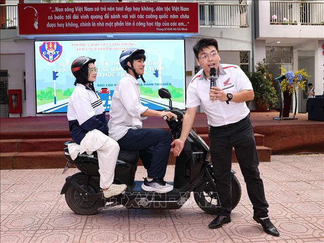 Nhân viên kỹ thuật của Honda hướng dẫn học sinh các thao tác sử dụng xe máy điện an toàn. Ảnh: Thanh Tùng - TTXVN 