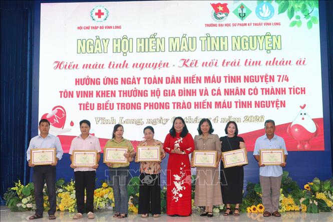 Khen thưởng các gia đình có thành tích tiêu biểu trong phong trào hiến máu tình nguyện. Ảnh: Lê Thúy Hằng – TTXVN. 