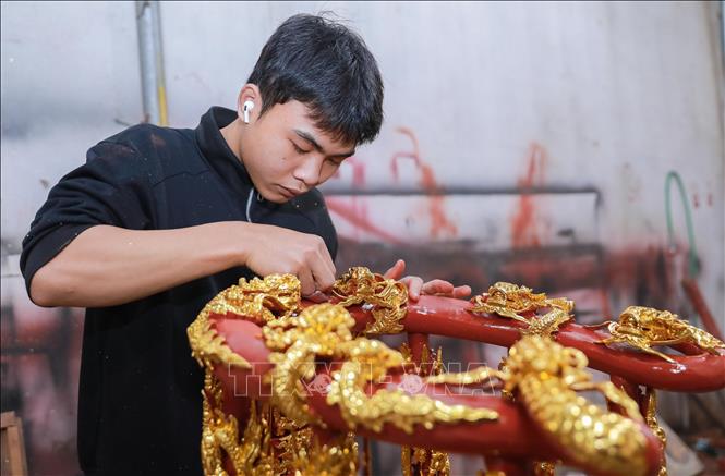 Cơ sở của nghệ nhân Lê Bá Chiếu khéo léo sử dụng vàng công nghiệp nhằm tối ưu chi phí. Dù thay đổi nguyên liệu, quy trình vẫn tuân thủ nghiêm ngặt kỹ thuật truyền thống, đảm bảo đường nét tinh xảo và giữ trọn vẻ đẹp vàng son đặc trưng. Ảnh: Phan Phương – TTXVN