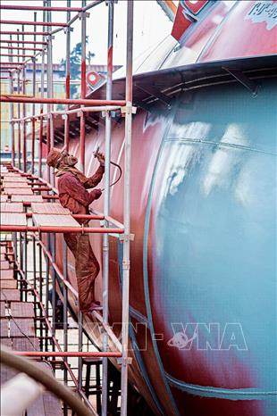 Người thợ Nhà máy đóng tàu Bạch Đằng thực hiện quy trình sơn chống gỉ bồn chứa chuyên dụng. Ảnh: Lan Anh/TTXVN phát
