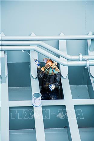 Di chuyển trên những thanh dầm hẹp, người thợ tập trung sơn phủ từng ngóc ngách của khung xương thép để tạo lớp 