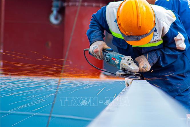 Công nhân dùng máy mài để làm phẳng các mối hàn thô, đảm bảo độ nhẵn mịn và chuẩn bị bề mặt cho các công đoạn tiếp theo. Ảnh: Lan Anh/TTXVN phát
