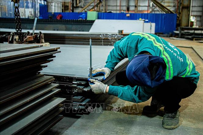 Đo đạc, kiểm tra kích thước các tấm thép trước khi gia công, đảm bảo độ chính xác theo bản vẽ kỹ thuật để chuyển sang các công đoạn tiếp theo. Ảnh: Lan Anh/TTXVN phát 
