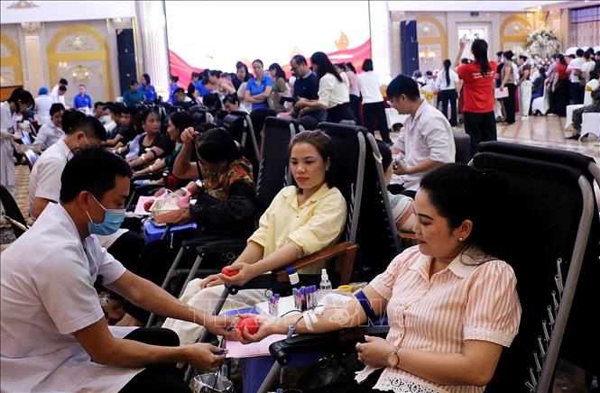 Cán bộ y tế giám sát thực hiện lấy máu người hiến máu tình nguyện. Ảnh: Thanh Hải - TTXVN 