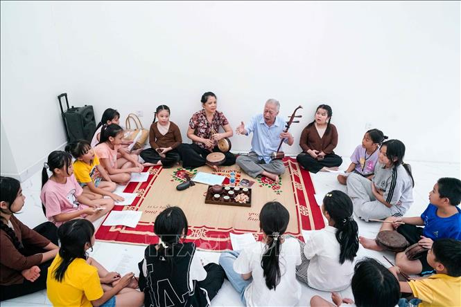 NSND Xuân Hoạch truyền dạy những giai điệu của Xẩm truyền thống đến với các bạn nhỏ. Ảnh: Khánh Hoà - TTXVN