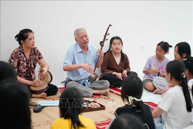 NSND Xuân Hoạch truyền dạy những giai điệu của Xẩm truyền thống đến với các bạn nhỏ. Ảnh: Khánh Hoà - TTXVN