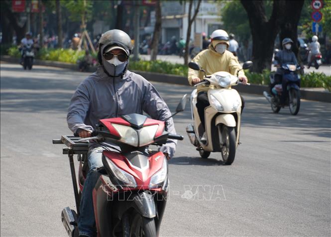 Người dân thành phố Huế mặc đồ bảo hộ chống nắng, khi di chuyển trên đường Trần Hưng Đạo, phường Phú Xuân. Ảnh: Nguyên Lý - TTXVN
