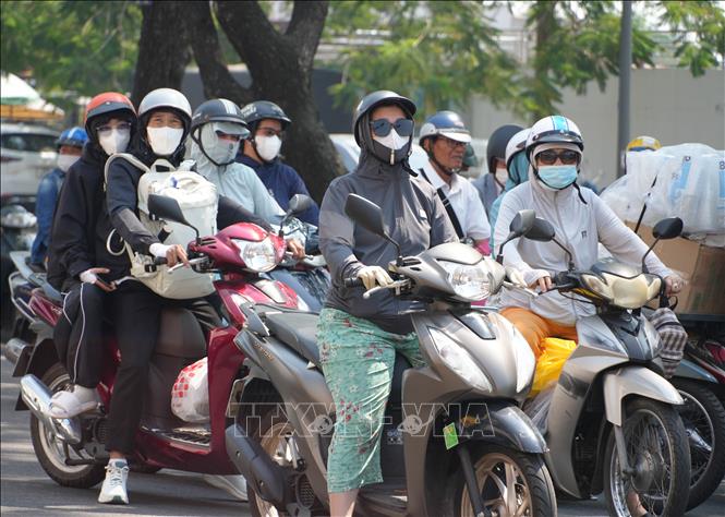 Người dân thành phố Huế mặc đồ bảo hộ chống nắng, khi di chuyển trên đường Trần Hưng Đạo, phường Phú Xuân. Ảnh: Nguyên Lý - TTXVN