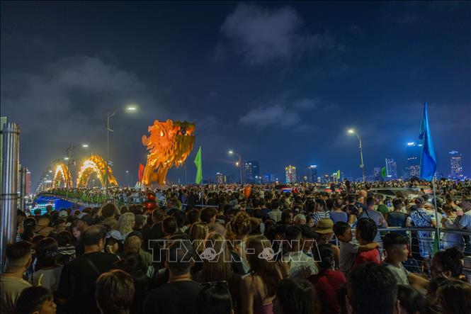 On weekends, locals and tourists often gather in large numbers at the Dragon Bridge to enjoy the water and fire show. VNA Photo: Xuân Quý
