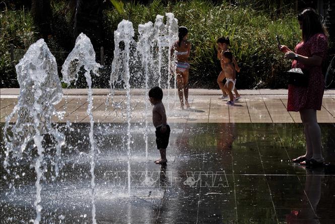 Người dân tránh nóng bên đài phun nước tại Nice, Pháp. Ảnh: THX/TTXVN