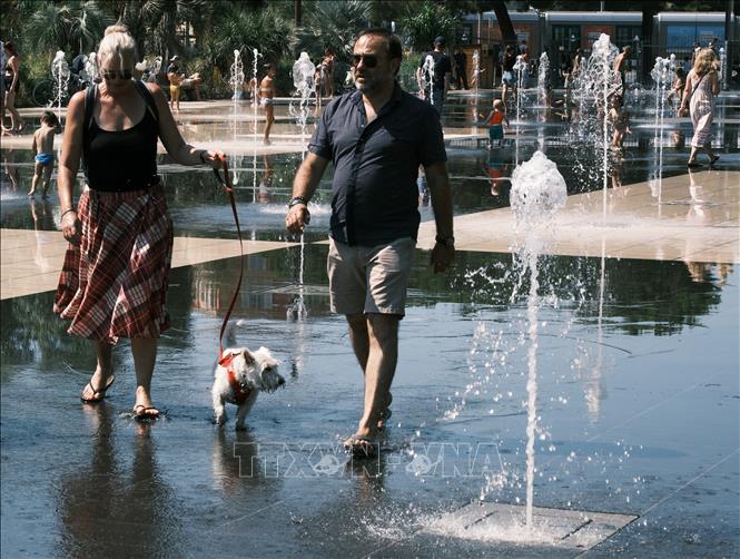 Người dân tránh nóng bên đài phun nước tại Nice, Pháp. Ảnh: THX/TTXVN