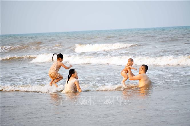Các gia đình lựa chọn bãi biển Xuân Thành (xã Nghi Xuân) để giải nhiệt trong những ngày nắng nóng. Ảnh: Hữu Quyết - TTXVN
