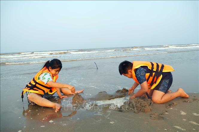 Bãi biển là nơi hấp dẫn đối với các em nhỏ. Ảnh: Hữu Quyết - TTXVN

