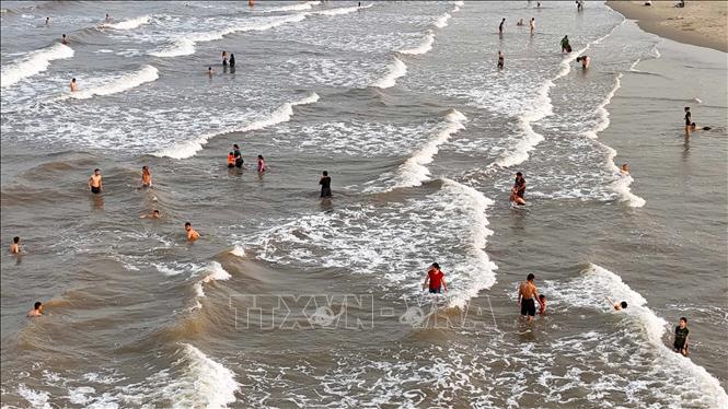 Du khách đổ về bãi biển Xuân Thành (xã Tiên Điền) để giải nhiệt. Ảnh: Hữu Quyết - TTXVN
