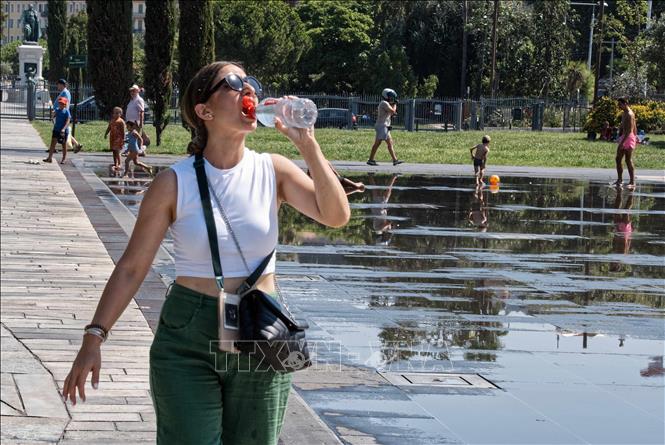 Người dân uống nước giải nhiệt tại Nice, Pháp. Ảnh: THX/TTXVN