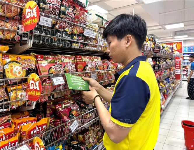 Nhân viên siêu thị GO!, TP. Hồ Chí Minh dán biển thu phí với túi ni lông sinh học tự hủy để nâng cao nhận thức người tiêu dùng khi đi mua sắm tại hệ thống. Ảnh: Hương Giang – TTXVN