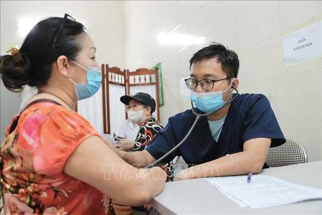 Bác sĩ bệnh viện Thanh Nhàn khám, tư vấn sức khoẻ cho người dân phường Bạch Mai đến khám tại điểm trạm Trương Định. Ảnh: Minh Quyết - TTXVN