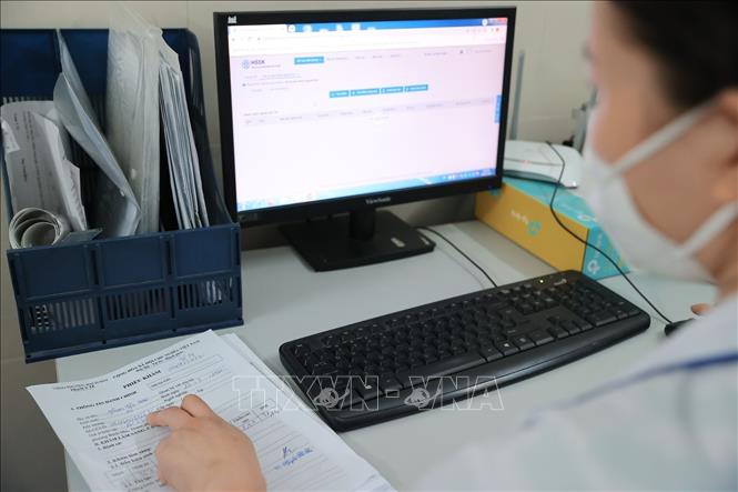 Nhân viên y tế Trạm Y tế phường Bạch Mai cập nhật thông tin, hồ sơ của bệnh nhân lên hệ thống Hồ sơ sức khoẻ điện tử của Thành phố. Ảnh: Minh Quyết - TTXVN 